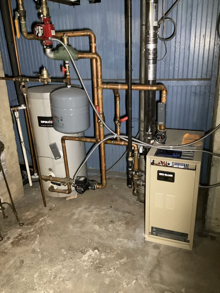 A basement setup with a gas furnace and water heater