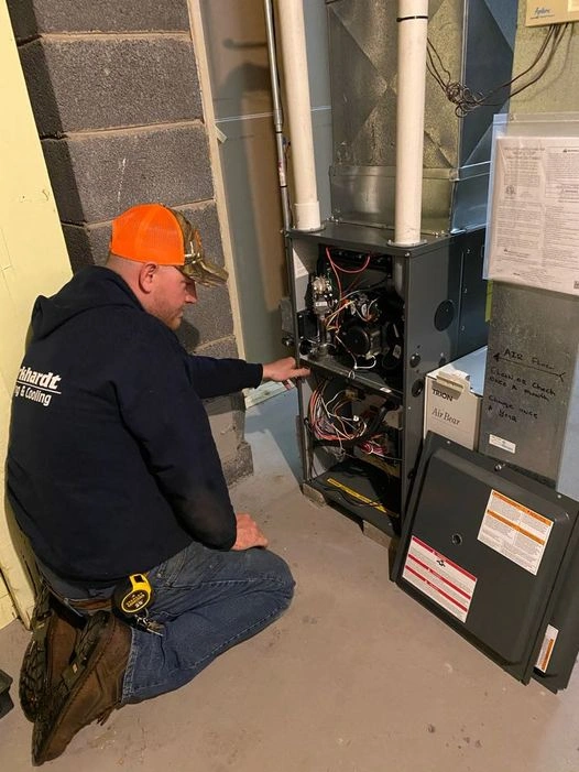 A man is engaged in maintenance work on a furnace